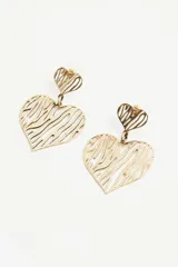 Aros colgantes dorados con forma de corazón calado y diseño abstracto.