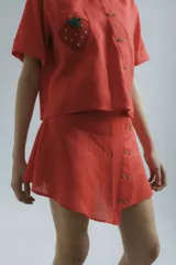 Minifalda de lino color coral con cierre lateral con botones de madera.