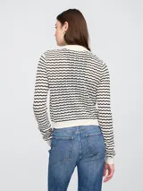 Saco tipo cárdigan de tejido de punto con rayas horizontales negras y crudas, cuello polo y cierre frontal con botones.