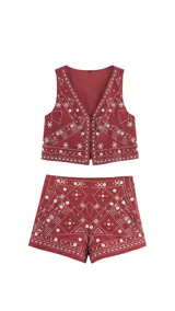 Conjunto de chaleco y short color ladrillo con bordados blancos de motivos geométricos y florales.