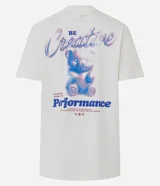 Remera de algodón color blanco tiza, manga corta y cuello redondo. Presenta un estampado grande en la espalda con la palabra "Creative" en tipografía cursiva iridiscente, un oso de goma con efecto holográfico en tonos azules y rosados, y el texto "MATTERS MORE THAN P¡FORMACE" debajo.