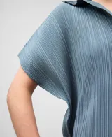 Camisa de poliéster reciclado color gris azul con textura crinkle. Presenta cuello solapa, manga corta redondeada y botonadura frontal oculta.