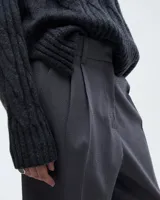 Pantalón pinzado sastrero color marrón claro, confeccionado en tela italiana de lana y elastano, de tiro medio/alto y largo hasta los tobillos. Presenta una silueta baggy, cintura prearmada, cartera con cierre y botón, bolsillos laterales funcionales y doble pinza en cada pierna. En la espalda, pinzas y un bolsillo ojal con presilla y botón.