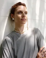 Aros tipo botón dorados con textura irregular que simula la superficie de un molusco.