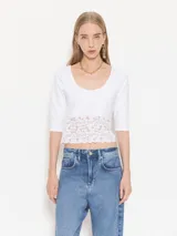 Top de algodón con lycra color blanco, de manga 3/4 y escote redondo, con detalle de puntilla en la parte inferior.