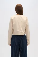 Chaqueta corta de algodón con estampado animal print en tonos grisáceos, cuello redondo, cierre frontal con botones a presión, bolsillos de parche en el pecho y corte recto.