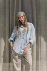 Camisa celeste de lino, corte oversize, con cuello clásico y mangas largas con puños abotonados.