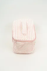 Neceser rectangular con cierre de cremallera, confeccionado en tejido de toalla con textura de motitas en color blanco y rosa pastel.