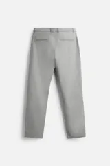 Pantalón negro de corte slim fit, confeccionado en tejido elástico. Cuenta con cintura elástica, bolsillos frontales y traseros de vivo. Cierre frontal con cremallera y botón.