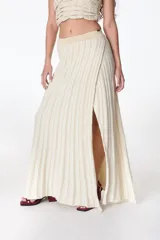 Falda midi tejida a rayas verticales en tonos celeste y azul, con cintura elástica y abertura lateral.