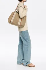 Bolso shopper horizontal marca Bimba y Lola, color beige, con doble asa de mano con detalles en cuero marrón, cierre con botón a presión y bolsillo interior con cremallera.