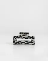 Broche rectangular para el pelo con diseño de cebra en blanco y negro.