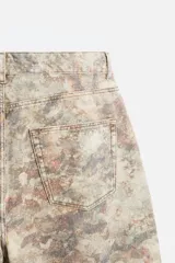 Pantalón de jean de corte recto con estampado abstracto en tonos beige, marrón y gris.