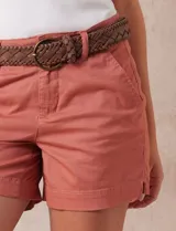 Short de jean azul oscuro con pretina con pasadores, botón y cierre. Delantera con bolsillos. Botón en bolsillos traseros. Incluye cinturón trenzado marrón con hebilla redonda dorada.
