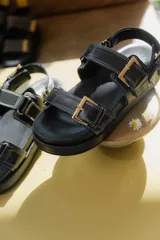 Sandalias de cuero color marrón con plataforma forrada en cuero y hebillas doradas.