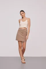 Top de bretel fino color crema, liso, al cuerpo y con escote en V.