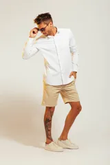 Camisa blanca de vestir con finas rayas verticales celestes, de corte clásico y manga larga.