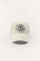 Gorra color crudo con visera y bordado frontal con el texto "Zara A Coruña Est. 1975 50 Years". Ajuste regulable en la parte posterior.