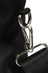 Bolso tipo tote de nylon negro, con asas de mano y correa ajustable para hombro. Presenta un bolsillo frontal con solapa y un detalle de cordón trenzado colgante.