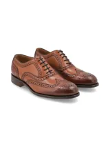 Zapato de vestir acordonado color cognac, estilo wingtip, con detalles de perforaciones y costuras decorativas.