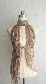 Top halter con estampado animal print en tonos beige y marrón, con cuello alto y abertura en el frente.