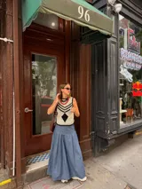 Falda larga de tela de jean con diseño de caderín y tablas.