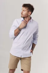 Camisa blanca de corte slim fit, manga larga y cuello clásico. Cierre frontal con botones.