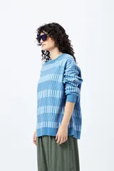 Sweater tejido en jacquard con diseño de franjas geométricas en tonos de azul.