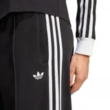 Pantalón deportivo Adidas de corte ancho, color negro, con cintura elástica y logo bordado en blanco. Presenta las tres líneas características de la marca a lo largo de las piernas.