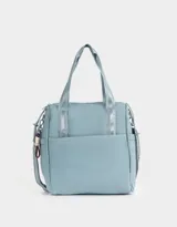 Cartera shopper color celeste con doble asa corta estampada, correa regulable y desmontable, cierre superior y charm lateral.