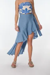 Falda cruzada (wrap skirt) de lino color azul claro, con ruedo asimétrico y volado.