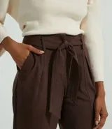 Pantalón clochard marrón de fake suede, con cinturón, pliegues y recortes.