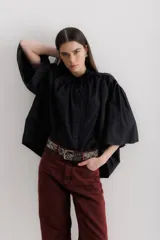 Camisa celeste de algodón con corte amplio, cuello camisero y mangas largas con puños abullonados.