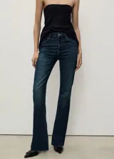 Pantalón de jean azul oscuro, de tiro medio y corte flare.
