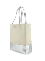 Bolso tipo tote bag color beige con base plateada, doble asa de hombro plateada y logo de la marca en el frente.