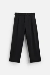 Pantalón negro de corte amplio, con pliegues frontales, bolsillos laterales y traseros de ojal. Incluye cinturón de la misma tela con hebilla metálica.