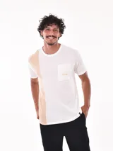 Remera negra de corte oversized con bolsillo en el pecho y detalle de bloque gris en el lateral.