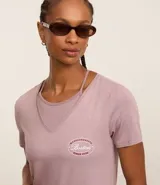 Remera deportiva de viscosa color lila, con cuello en pico, mangas cortas y estampado "Boston" en el pecho.