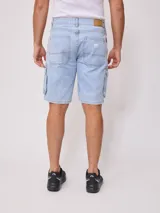 Bermuda de jean azul con bolsillos cargo laterales y corte a la rodilla.
