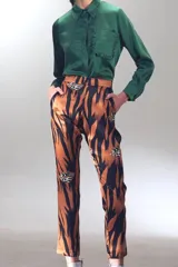 Pantalón de seda con estampado de tigre en tonos naranjas y negros, de tiro alto y corte suelto hasta el tobillo.