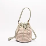 Bolso tipo saco (bucket bag) de mujer, con cuerpo tejido en rafia color beige y detalles, asa superior y correa ajustable larga en cuero sintético color verde menta. Cierre de cordón ajustable en la parte superior.