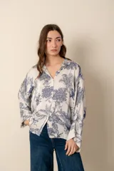 Camisa blanca con estampado de diseño bandana en tonos beige, de corte amplio, con cuello camisero y cierre frontal con botones.