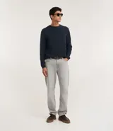 Suéter de punto color gris, con cuello redondo, manga larga y textura maquinetada.