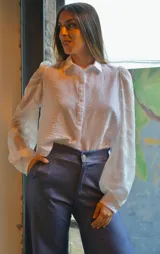 Camisa blanca con textura y mangas largas abullonadas de tela transparente con diseño de hojas.