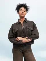 Campera de jean celeste con efecto lavado, corte cropped, cuello camisero, cierre frontal con botones metálicos, cuatro bolsillos frontales con solapa y puños abotonados.
