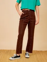 Pantalón jean marrón de corte recto, con bolsillos delanteros y traseros, y costuras en hilo blanco.