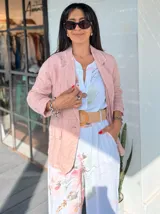 Blazer verde esmeralda de lino, con solapas de muesca, cierre frontal con dos botones y bolsillos laterales con solapa.