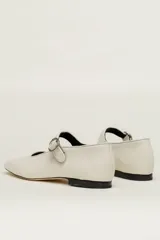 Zapato estilo Mary Jane color marrón, de cuero, con punta redondeada y tira sobre el empeine con hebilla.