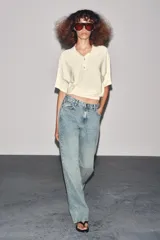 Pantalón de jean celeste de corte recto y tiro medio, con cinco bolsillos y cierre frontal con cremallera y botón metálico.