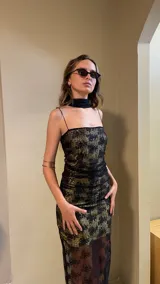 Vestido largo negro con estampado dorado, de breteles finos y corte ajustado.